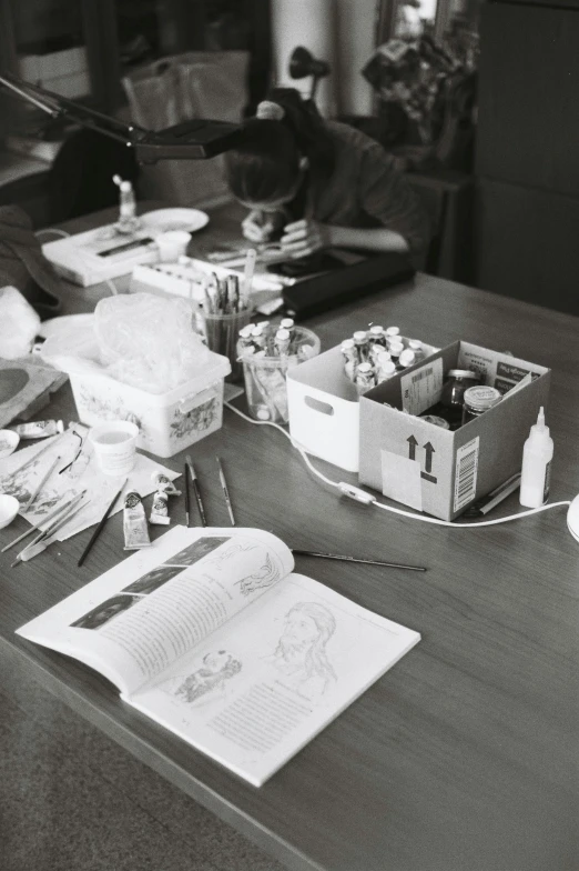 a black and white photo of a messy desk, by Jang Seung-eop, process art, ingredients on the table, group sit at table, cigarrette boxes at the table, instagram picture