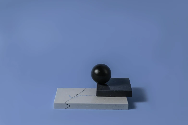 a black ball sitting on top of a piece of paper, an abstract sculpture, inspired by Isamu Noguchi, dribble, suprematism, blue marble, detailed product image, small stature, levitating