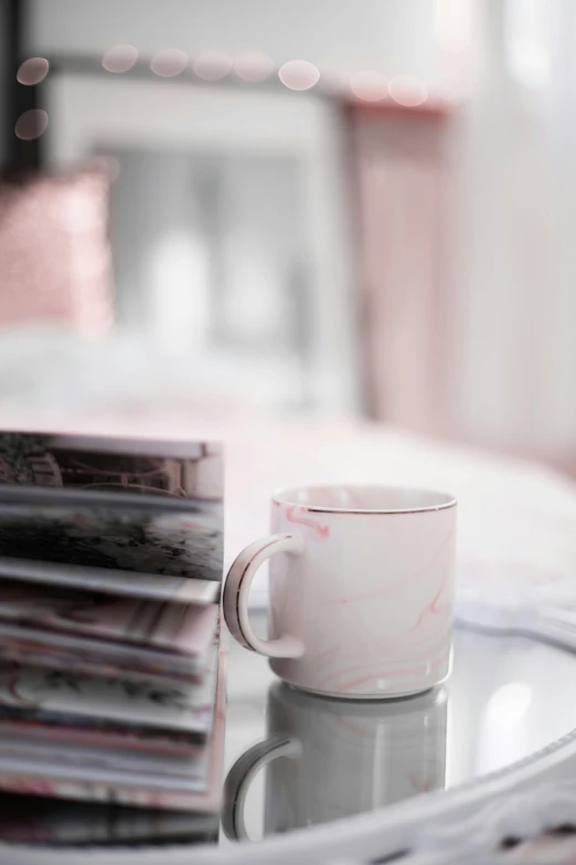 a coffee cup sitting on top of a glass table, featured on pinterest, light pink mist, marbled, sitting in bedroom, detailed product shot