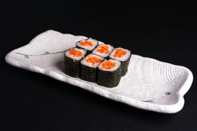 a close up of a plate with sushi on it, inspired by Maki Haku, unsplash, sōsaku hanga, 3/4 front view, 6 pack, vibrant orange, medium angle