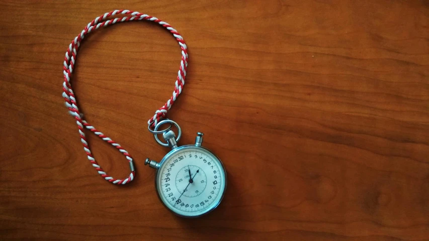 a pocket watch sitting on top of a wooden table, silver red white details, neuroscience, childhood memory, covid