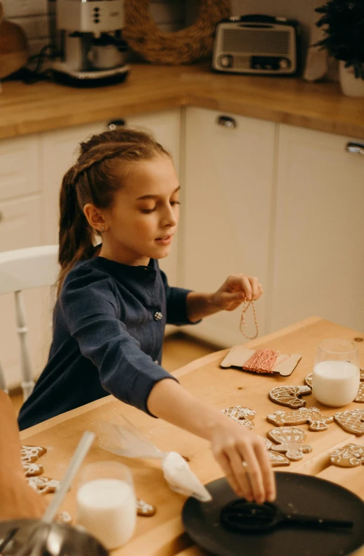 a little girl that is sitting at a table, organic ornaments, baking cookies, connectivity, hanging