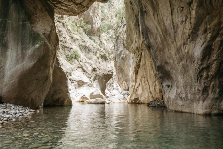 a body of water with a cave in the background, les nabis, mountain water, thumbnail, dry archways, grey