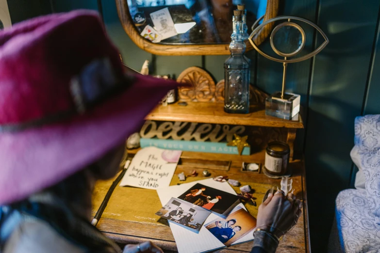 a woman sitting at a desk in front of a mirror, a picture, by Joe Bowler, unsplash, western saloon theme, with some hand written letters, tipping his fedora, event photography