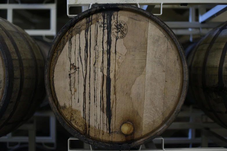 a bunch of wooden barrels stacked on top of each other, by Joe Stefanelli, process art, weeping tears of black oil, inside a beer glass, enso, view from the bottom