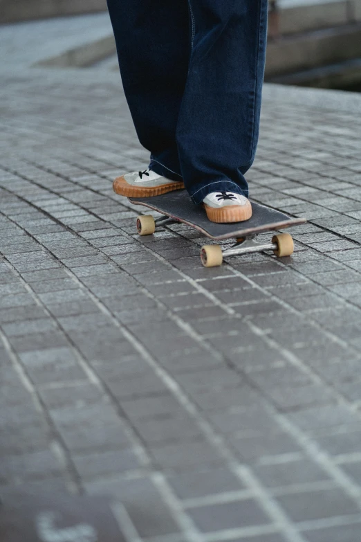 a person standing on a skateboard on a sidewalk, no cropping, square nose, brown, flattened