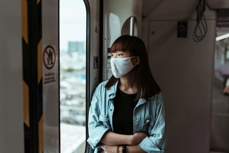 a woman wearing a face mask on a train, by Emma Andijewska, pexels contest winner, shin hanga, avatar image, korean girl, stood in a lab, 🚿🗝📝