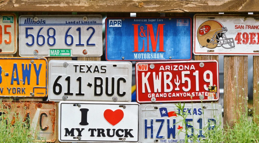 a pile of license plates sitting on top of a wooden fence, 9 9 designs, plates