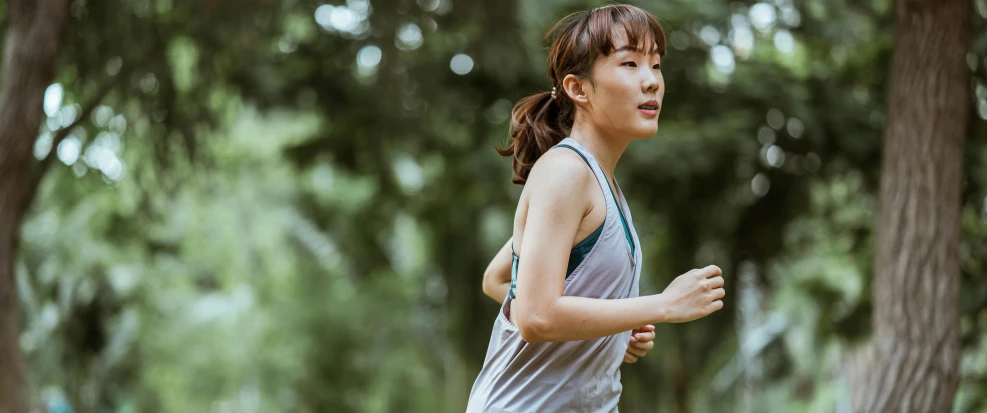 a woman running in a park with trees in the background, pexels contest winner, happening, ethnicity : japanese, cottagecore!! fitness body, profile image, sweating