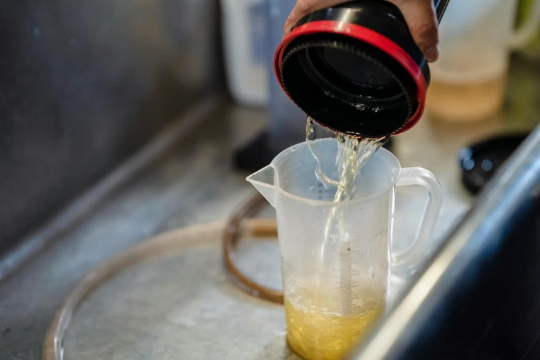 a person pouring liquid into a measuring cup, unsplash, duff beer, straining, very crispy, cast