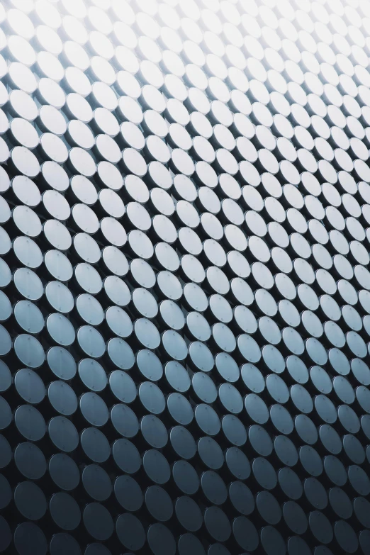 a wall that has a lot of circles on it, by Dave Allsop, trending on unsplash, kinetic pointillism, blue silver and black, made of nanomaterials, perforated metal, looking upwards