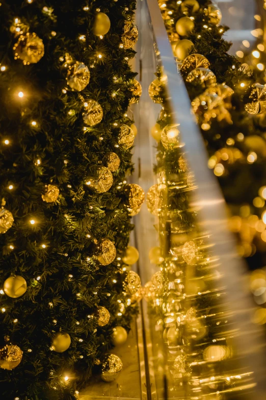 a lighted christmas tree in front of a building, by Jakob Gauermann, pexels, baroque, golden orbs, close up details, lush surroundings, golden ribbons