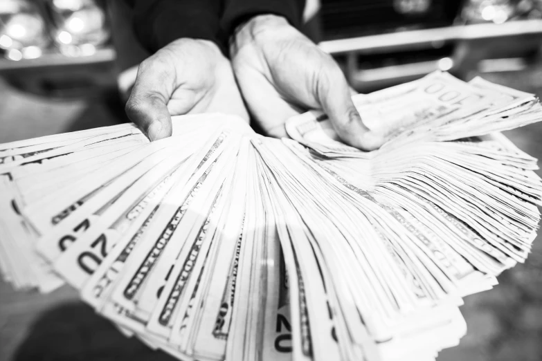 a person holding a bunch of money in their hands, a black and white photo, by Daniel Lieske, facebook photo, featured, stacks, crips details