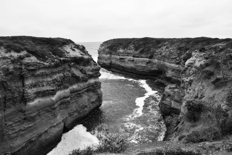 a black and white photo of the ocean, les nabis, huge chasm, melbourne, erosion channels river, lowres