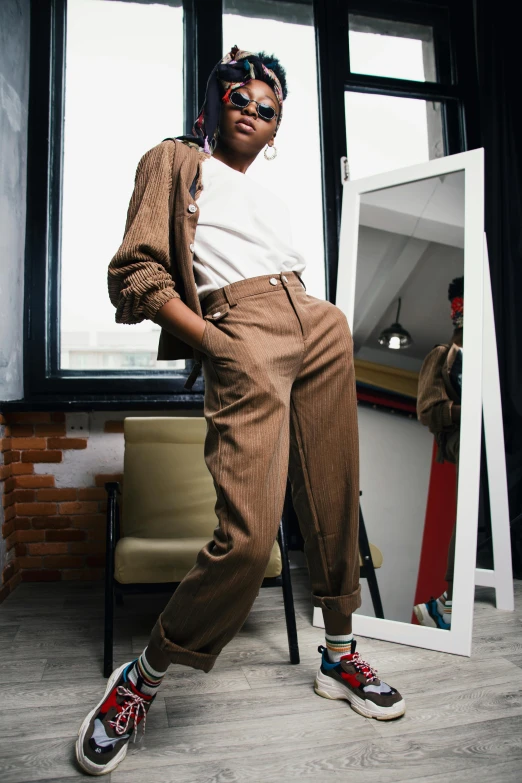 a man sitting on a chair in front of a mirror, by Nina Hamnett, trending on pexels, renaissance, wearing cargo pants, brown skinned, woman posing, tan suit