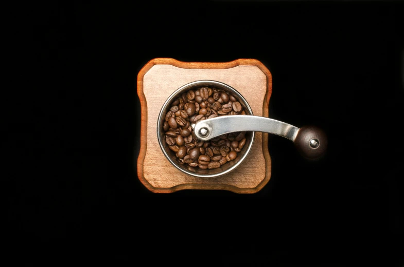 a coffee grinder filled with coffee beans, inspired by Ceferí Olivé, hurufiyya, on black background, birdseye view, listing image, fan favorite