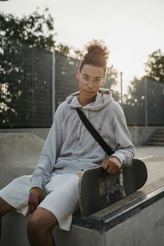 a young man sitting on a ledge with a skateboard, trending on unsplash, renaissance, portrait androgynous girl, gray hoodie, wearing white suit and glasses, bella poarch