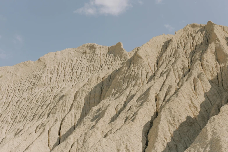 a man riding a snowboard up the side of a mountain, an album cover, trending on unsplash, les nabis, between sedimentary deposits, texture of sand, nadav kander, taupe