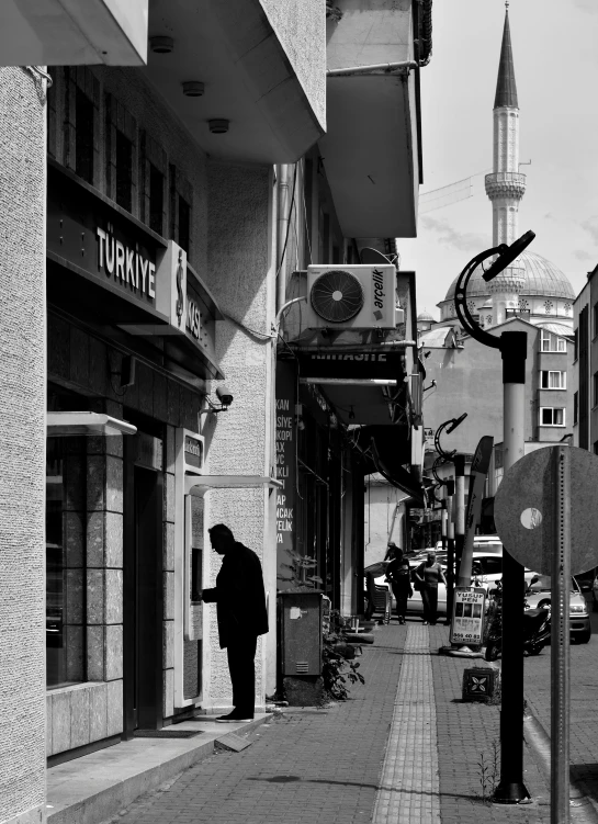 a black and white photo of a person walking down a street, a black and white photo, by Ismail Acar, hurufiyya, 2 2 nd century!!!!! town street, fallout style istanbul, japanese downtown, afternoon time