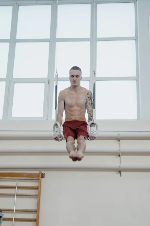 a man on a parallel bar in front of a window, a tattoo, inspired by Graham Forsythe, vitalik buterin, suspended underwater, official photo, film still dnd