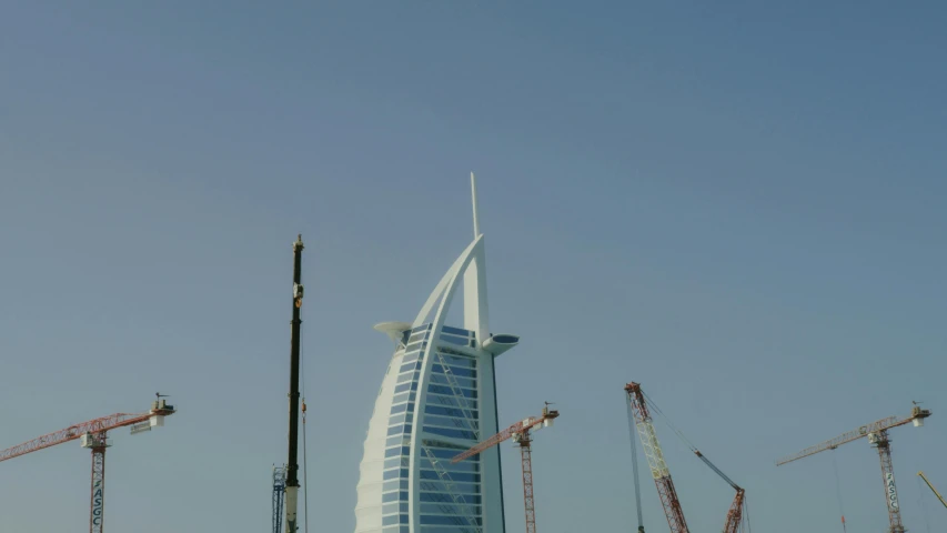 a group of cranes standing in front of a tall building, inspired by Victor Enrich, pexels contest winner, hurufiyya, gta : dubai, ships with sails underneath, portrait mode photo, [32k hd]^10