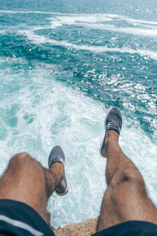 a man sitting on top of a rock next to the ocean, juicy legs, on a boat, real trending on instagram image, full frame image