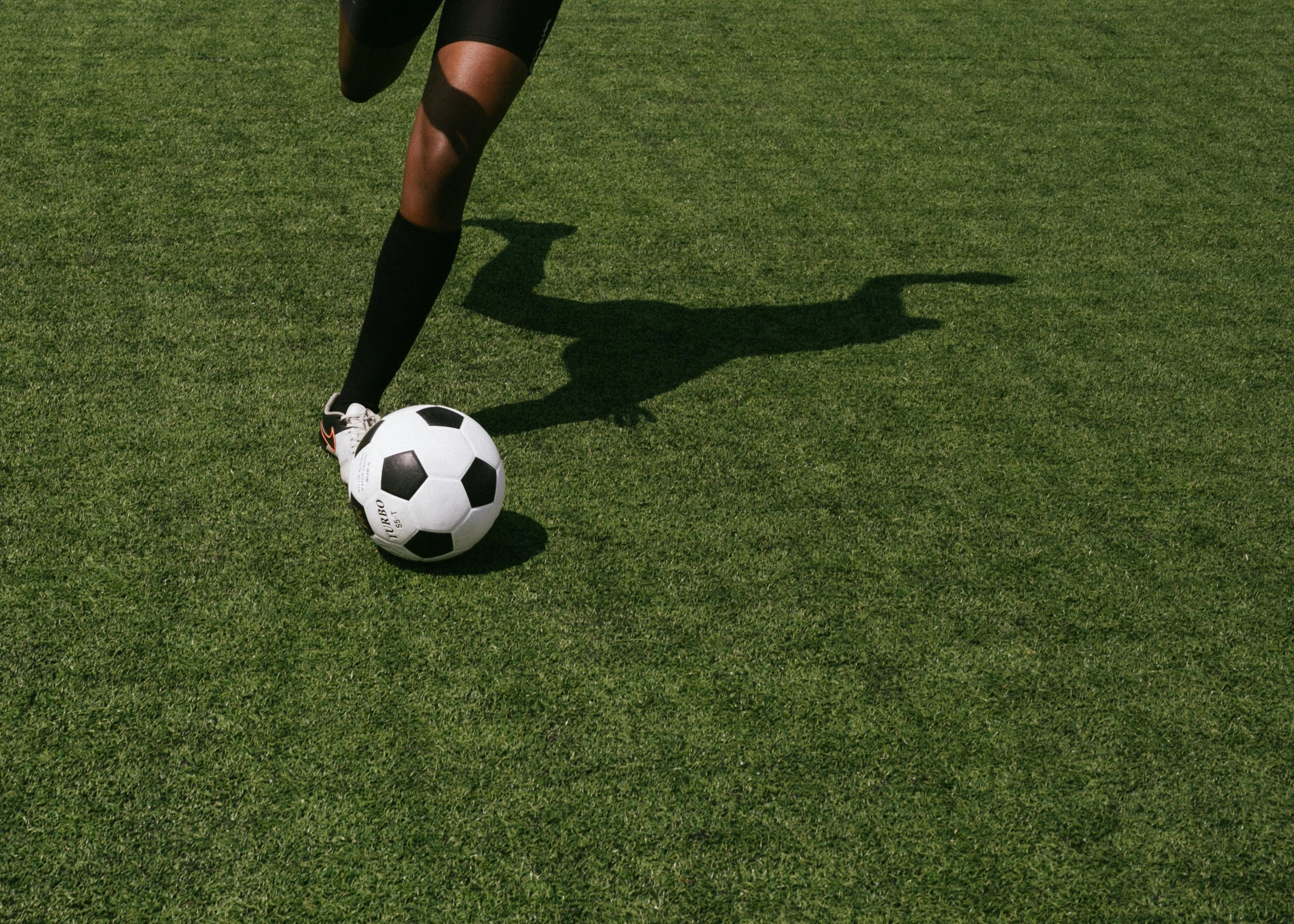 a person kicking a soccer ball on a field, an approaching shadow, 15081959 21121991 01012000 4k, fake grass, smooth surfaces