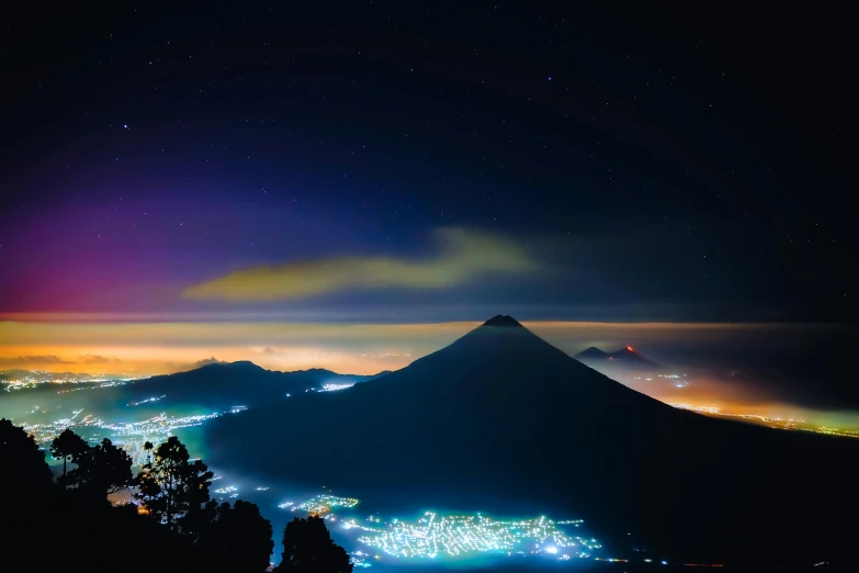 a mountain that has some lights on it, pexels contest winner, sumatraism, colorful haze, avatar image