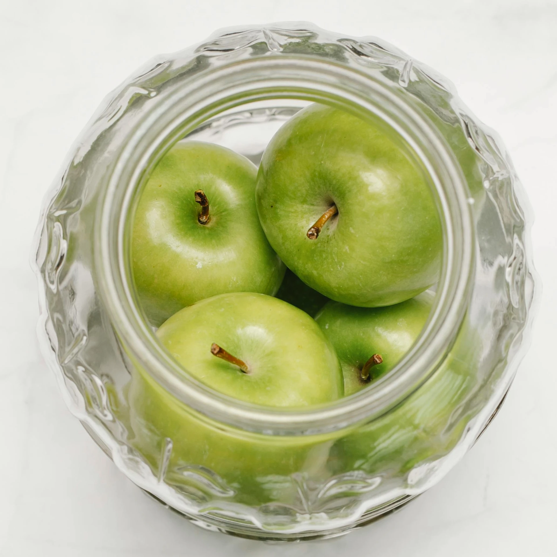 a glass bowl filled with green apples on top of a table, 6 pack, thumbnail, petite, jars