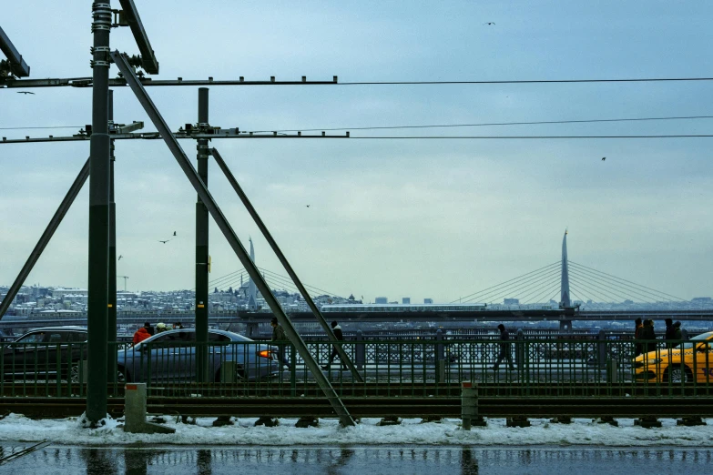 a train traveling down train tracks next to a bridge, by Sven Erixson, pexels contest winner, pylons, peter the great, city docks, birds in the distance