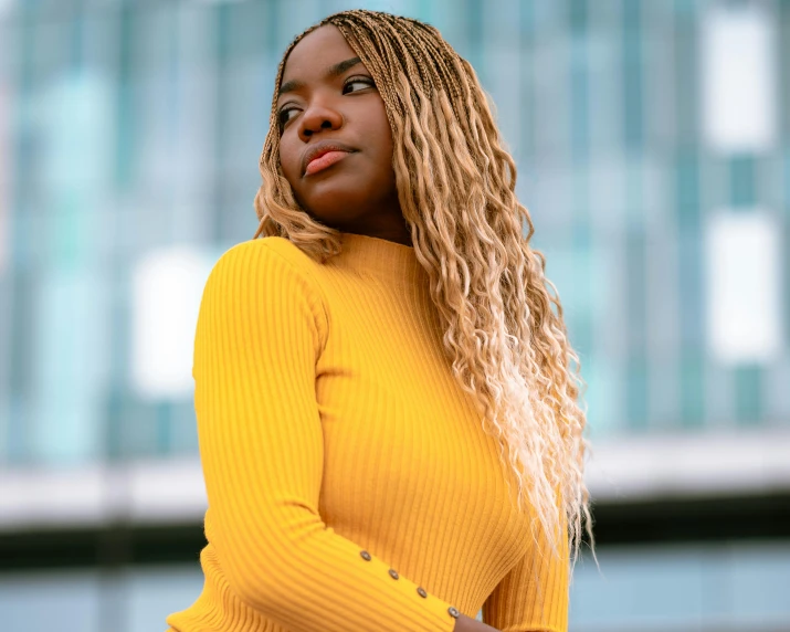 a woman in a yellow sweater poses for a picture, trending on pexels, maria borges, blonde flowing hair, thumbnail, curvy build