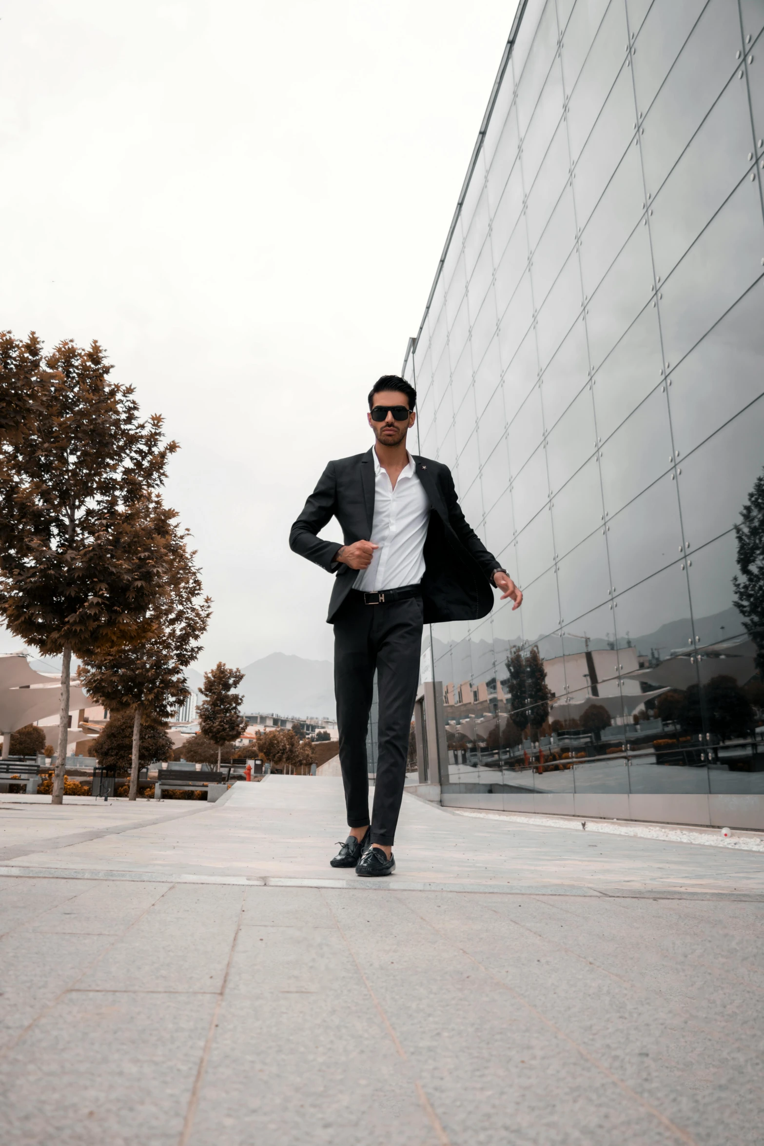 a man in a suit is walking down the street, pexels contest winner, modernism, full body with dynamic pose, doing a sassy pose, thumbnail, tall and lanky skinny