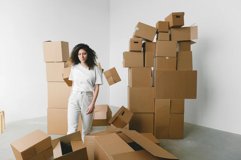a woman standing in front of a pile of cardboard boxes, curated collections, pokimane, proportional image, portrait image