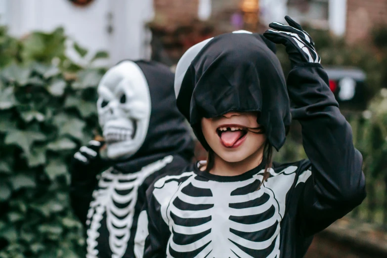 a little girl dressed up in a skeleton costume, a cartoon, pexels contest winner, shark teeth, declan mckenna, black, seasonal