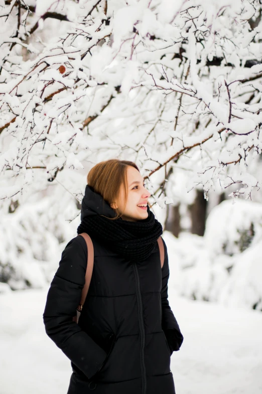 a woman standing under a tree covered in snow, profile image