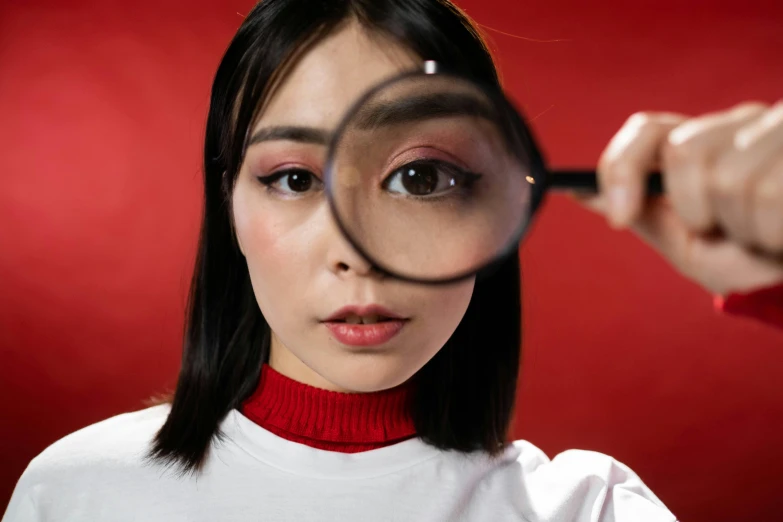 a woman looking through a magnifying glass, trending on pexels, hyperrealism, asian face, red, with big eyes, inspect in inventory image