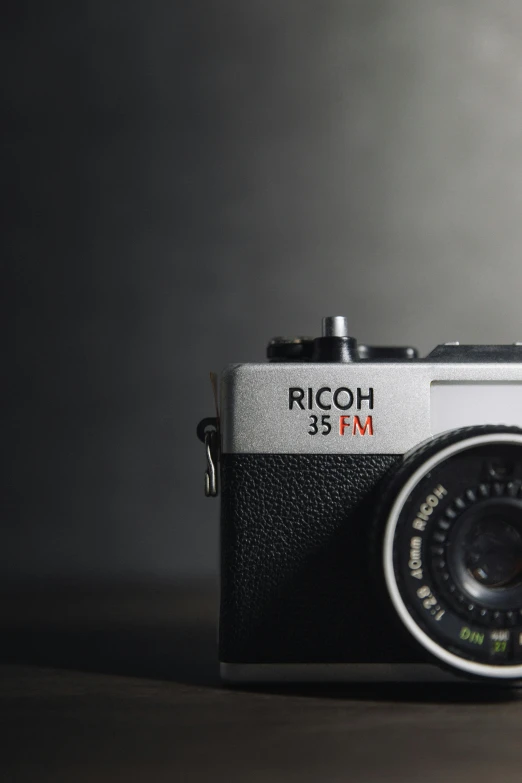 a close up of a camera on a table, by Andor Basch, unsplash contest winner, photorealism, on a gray background, rick dai, rich, 35mm —w 1920 —h 1080