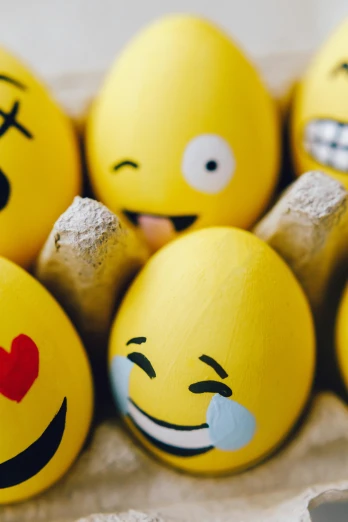 a carton of eggs with smiley faces painted on them, a picture, trending on pexels, graffiti, yellow uneven teeth, party balloons, religious, a still of a happy