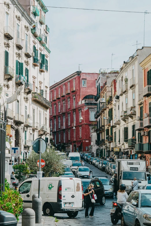 a street filled with lots of traffic next to tall buildings, by Anita Malfatti, pexels contest winner, renaissance, naples, payne's grey and venetian red, seen from outside, van