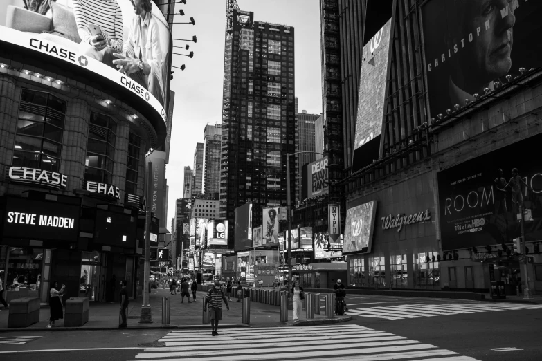 a black and white photo of a busy city street, a black and white photo, by Dennis Flanders, pexels, standing in time square, empty streetscapes, large commercial led screens, man walking through city