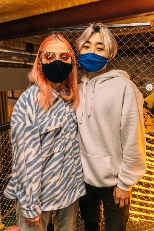 two people standing next to each other wearing face masks, an album cover, trending on pexels, she is wearing streetwear, fashion week backstage, split dye, & jeehyung lee & wlop