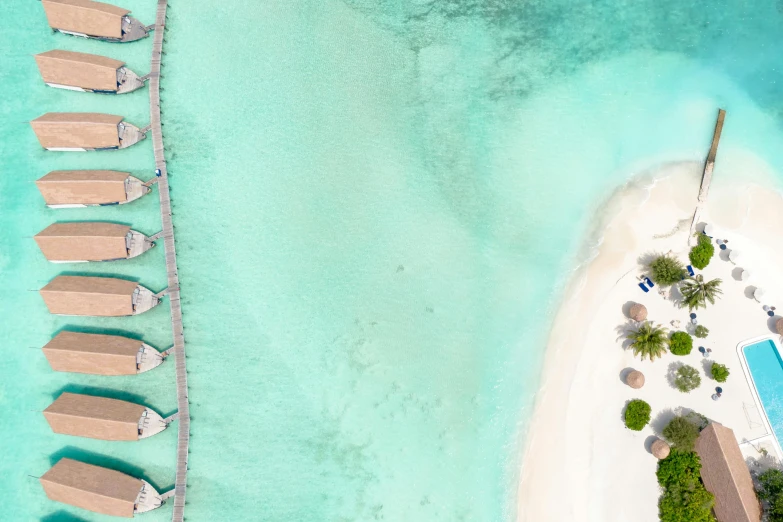 a group of boats sitting on top of a beach next to a body of water, a digital rendering, by Julian Allen, pexels contest winner, hurufiyya, satellite view, maldives in background, thumbnail, conde nast traveler photo
