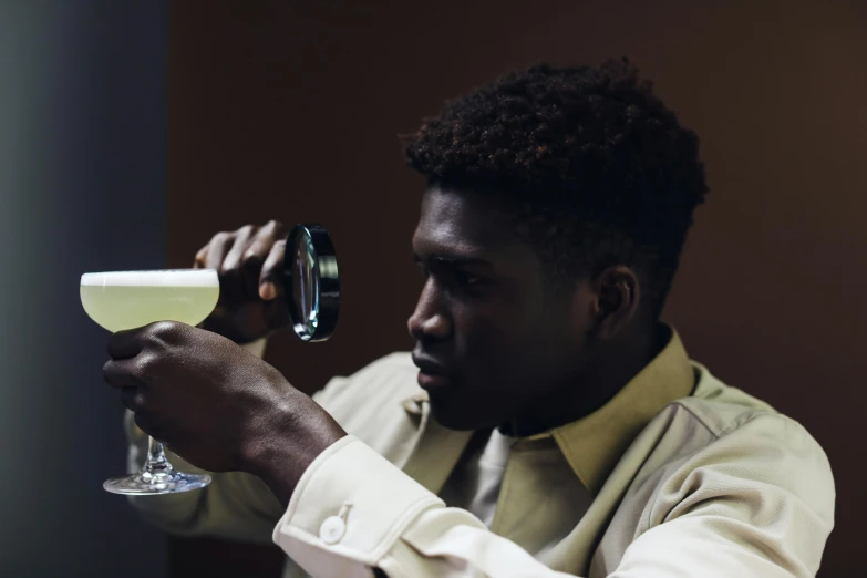 a man pouring a drink into a glass, inspired by Gillis Rombouts, pexels contest winner, man is with black skin, looking off to the side, ( ( theatrical ) ), young thug