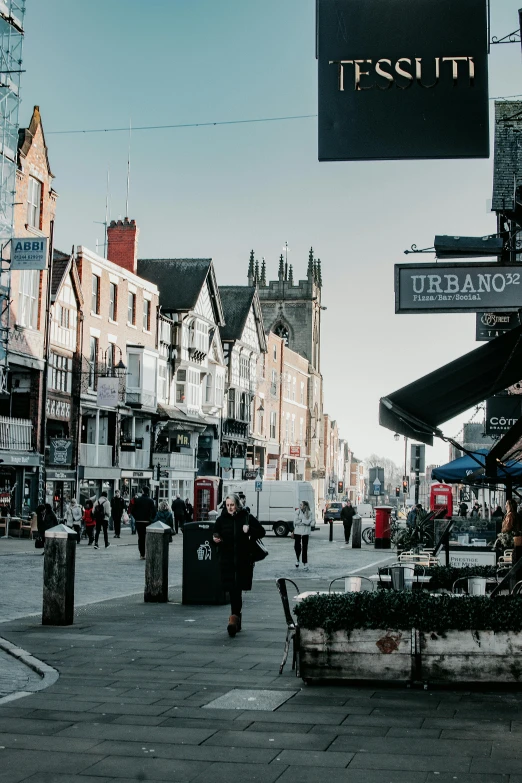 a group of people walking down a street next to tall buildings, by IAN SPRIGGS, trending on unsplash, renaissance, coventry city centre, lots of signs and shops, victorian buildings, panoramic