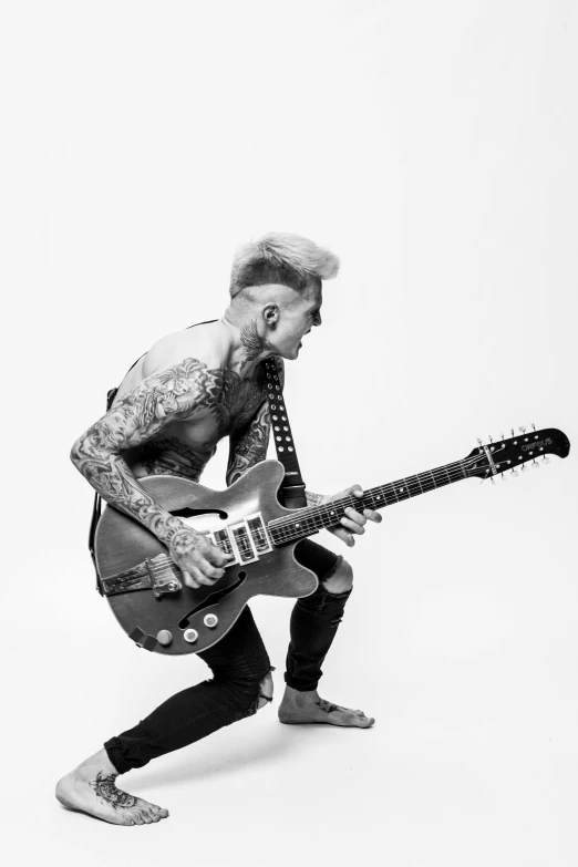 a black and white photo of a man playing a guitar, an album cover, inspired by Cam Sykes, tattooed man, non binary model, white mohawk, playing electric guitar