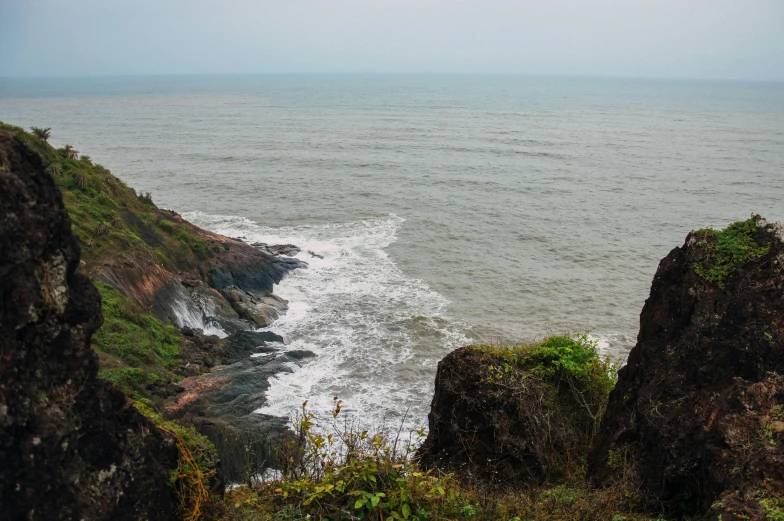 a view of the ocean from the top of a hill, vastayan, wet rocks, thumbnail, side - view