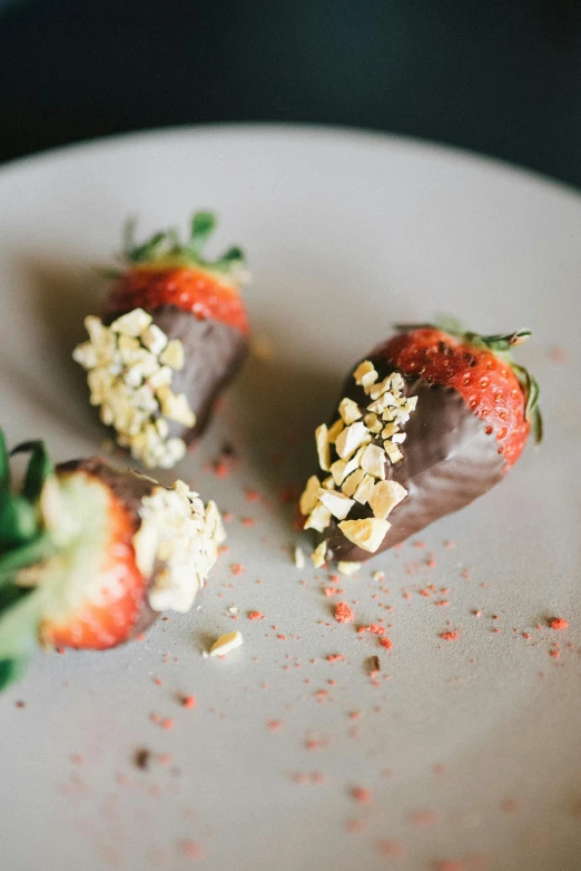 a white plate topped with chocolate covered strawberries, a still life, by Jessie Algie, unsplash, red and golden color details, rockets, cheesy, three quarter shot