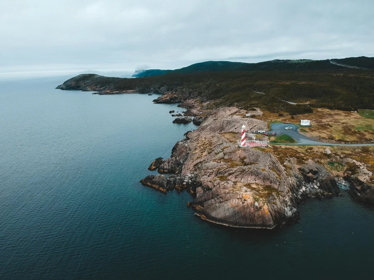 a small island in the middle of a body of water, by Lee Loughridge, pexels contest winner, a road leading to the lighthouse, helicopter view, francois legault, thumbnail