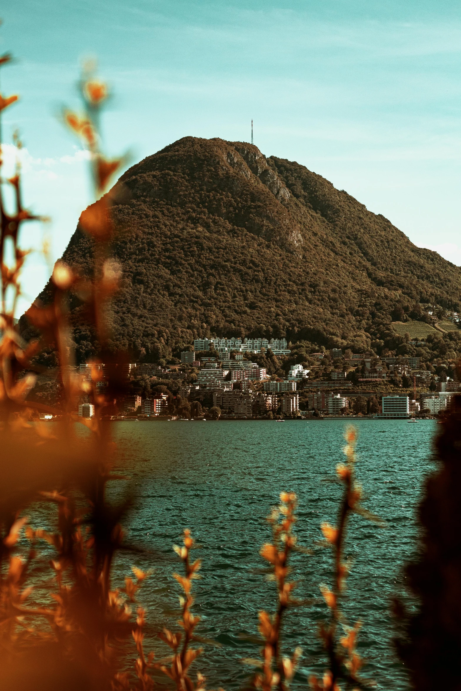 a body of water with a mountain in the background, by Tobias Stimmer, pexels contest winner, art nouveau, overgrown city, swiss modernizm, autum, pyramid surrounded with greenery