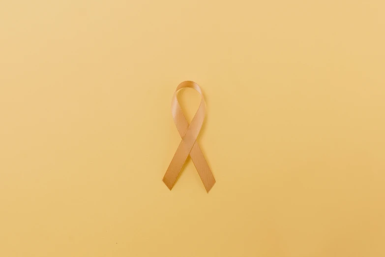 a pink ribbon on a yellow background, trending on pexels, hurufiyya, orange skin, cysts, 2 2 years old, light - brown wall